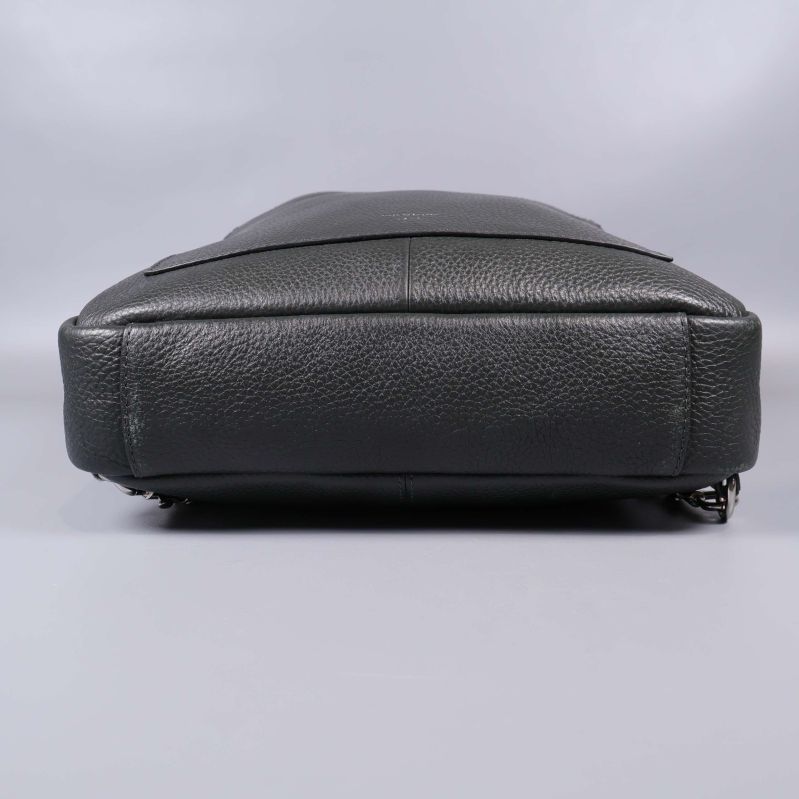 Undersida på svart läderryggsäck visar tåligt material