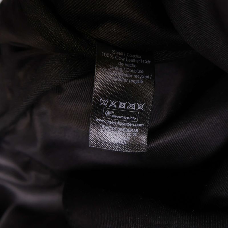 Materialetikett med information om läder och polyesterfoder