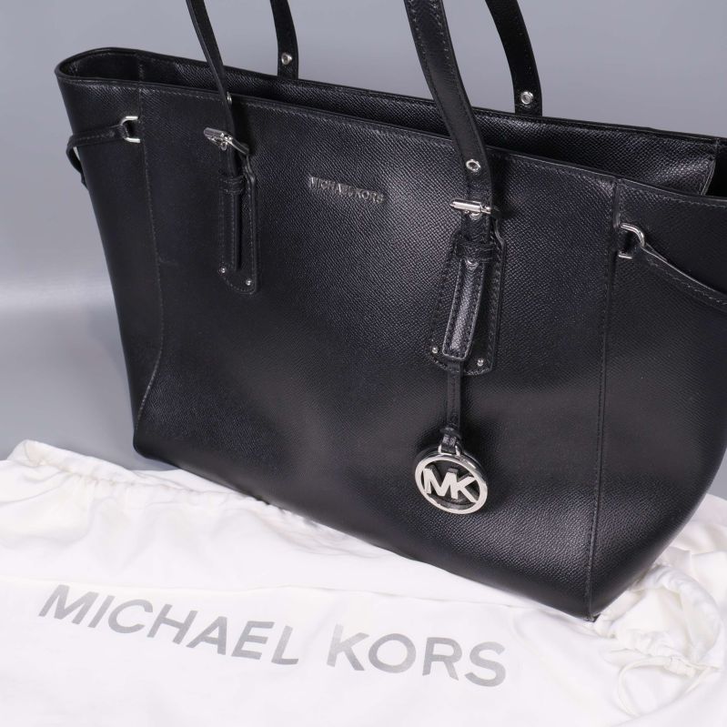 Närbild på svart Michael Kors väska och logotyp