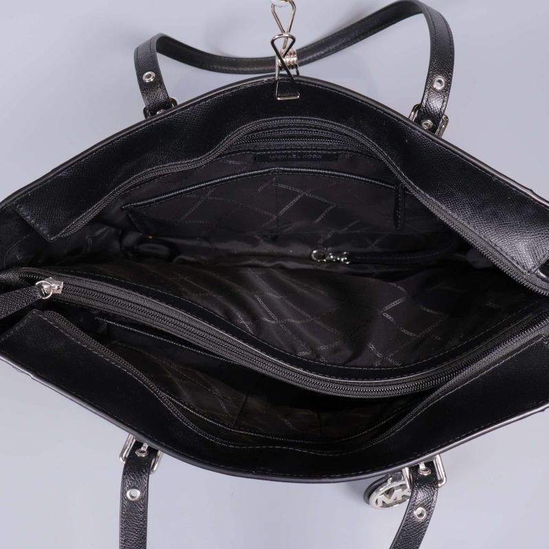 Insidan av svart axelväska med flera fack