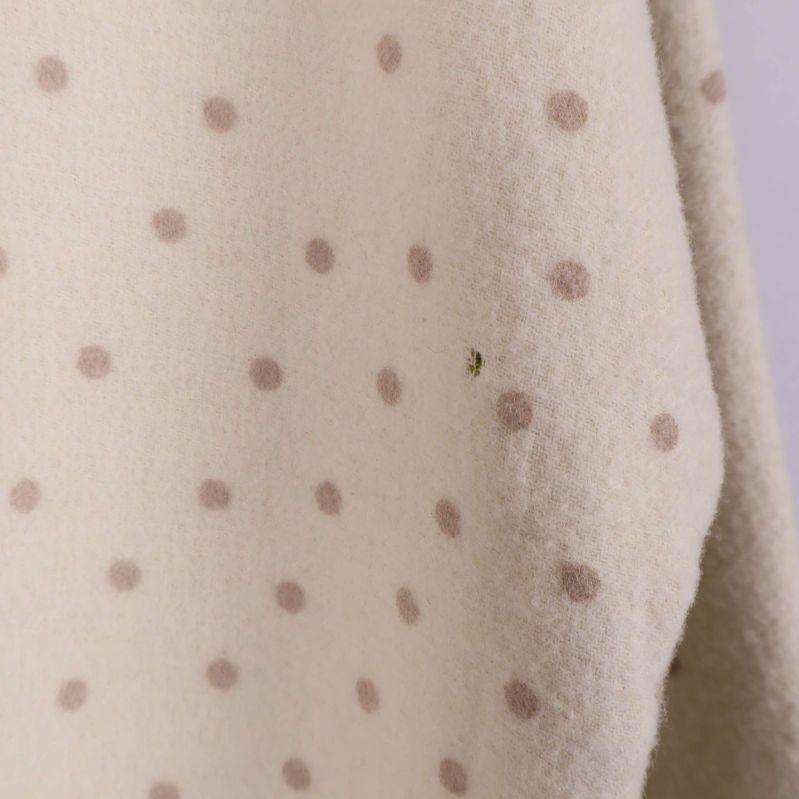 Närbild visar diskret hål vid prickmönster på ärm