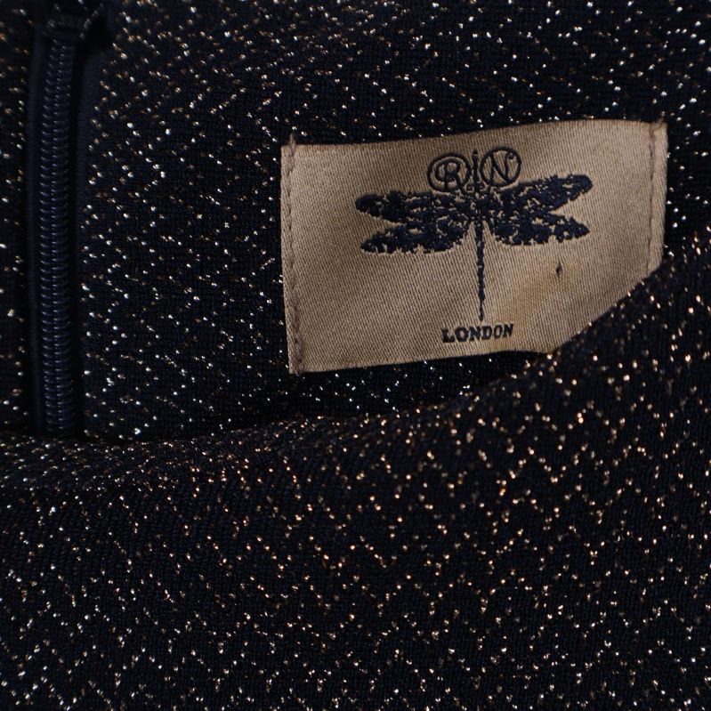 Närbild av etikett med trollslända och texten London