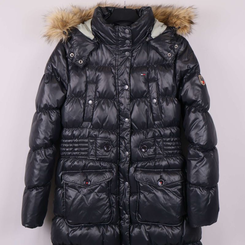 Framifrån lång svart jacka med detaljer vid fickor och midja