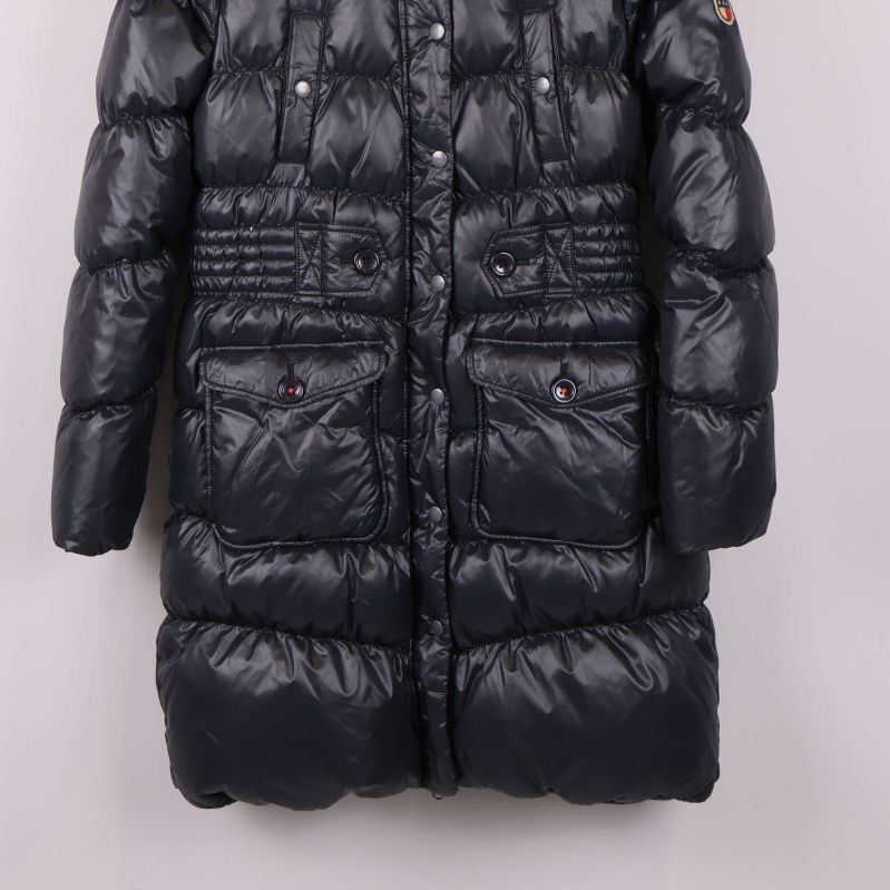 Nedre del av svart lång dunjacka med stora fickor