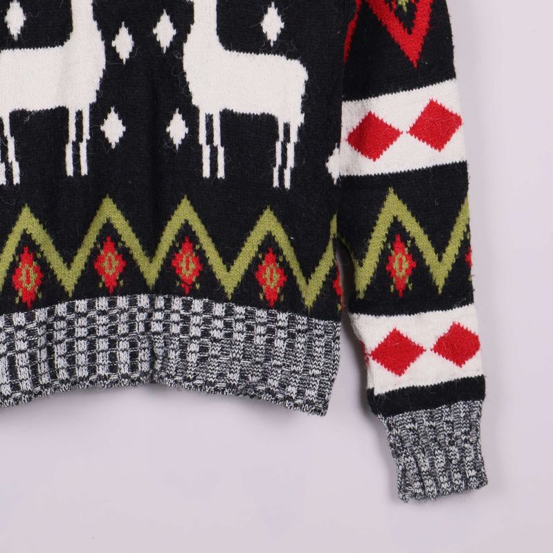 Närbild på andra ärmen och nederkant med grönt och rött mönster