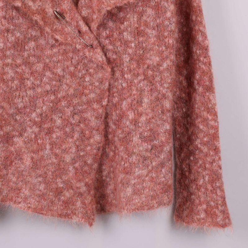 Stickad ärmdetalj i aprikos och vitmelerad garnblandning