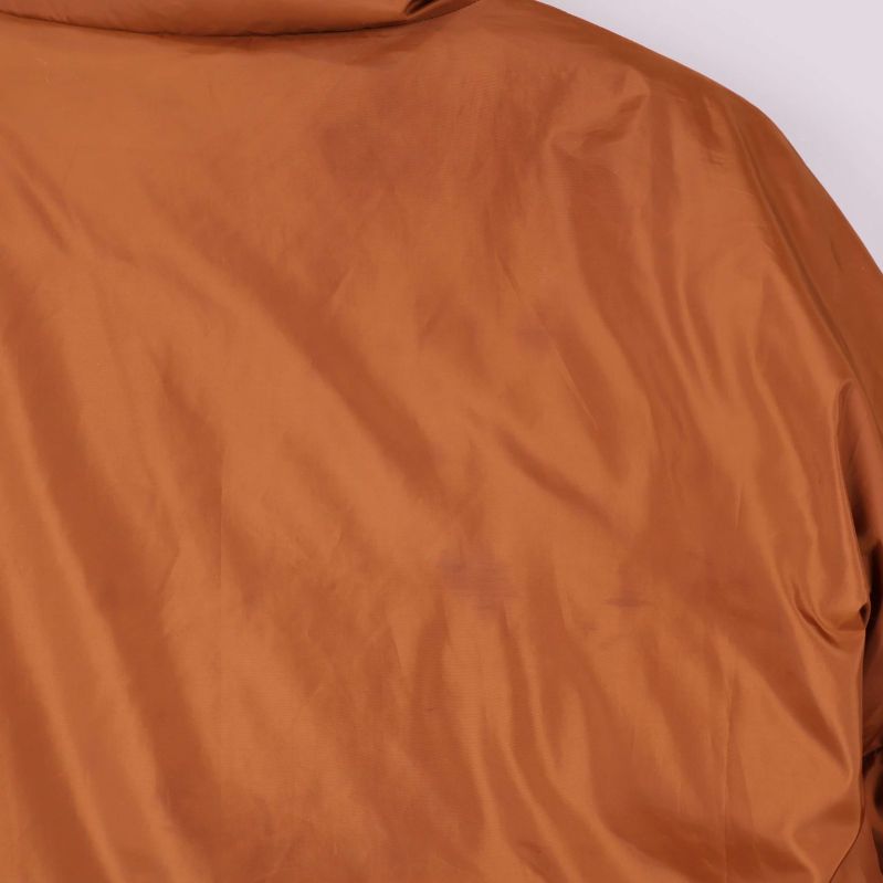 Närbild på material och yta baktill på brun jacka