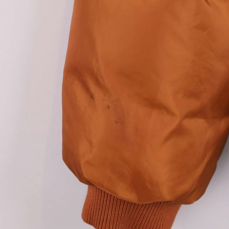 Närbild på vänster ärm med liten fläck på brun jacka