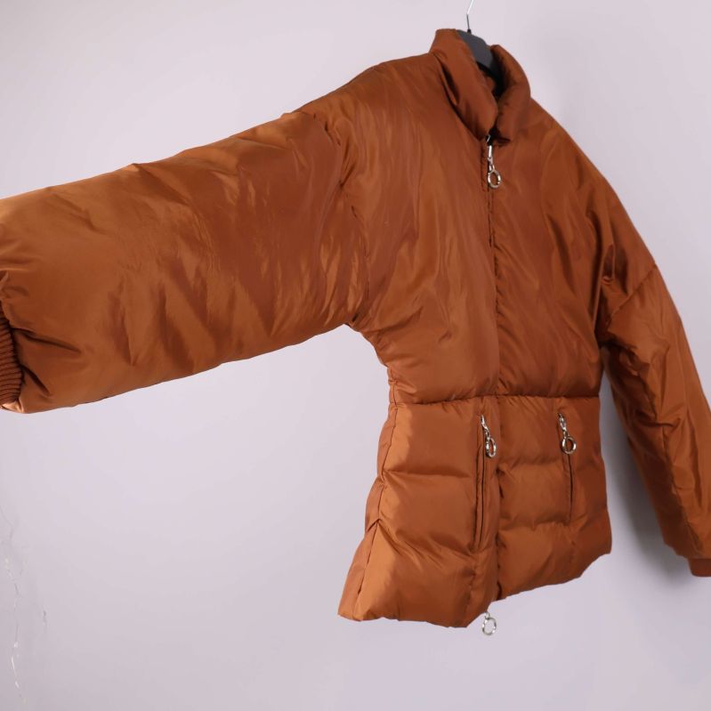 Brun vadderad jacka i profil med utsträckt ärm