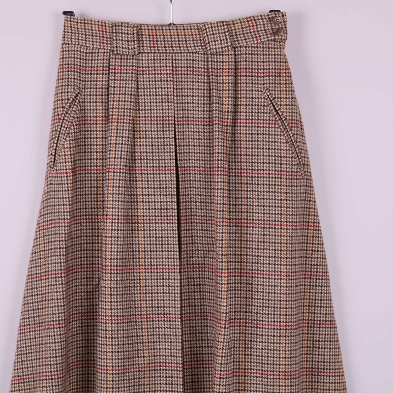 Framstycke på rutigt kjoltyg med pressveck och fickor