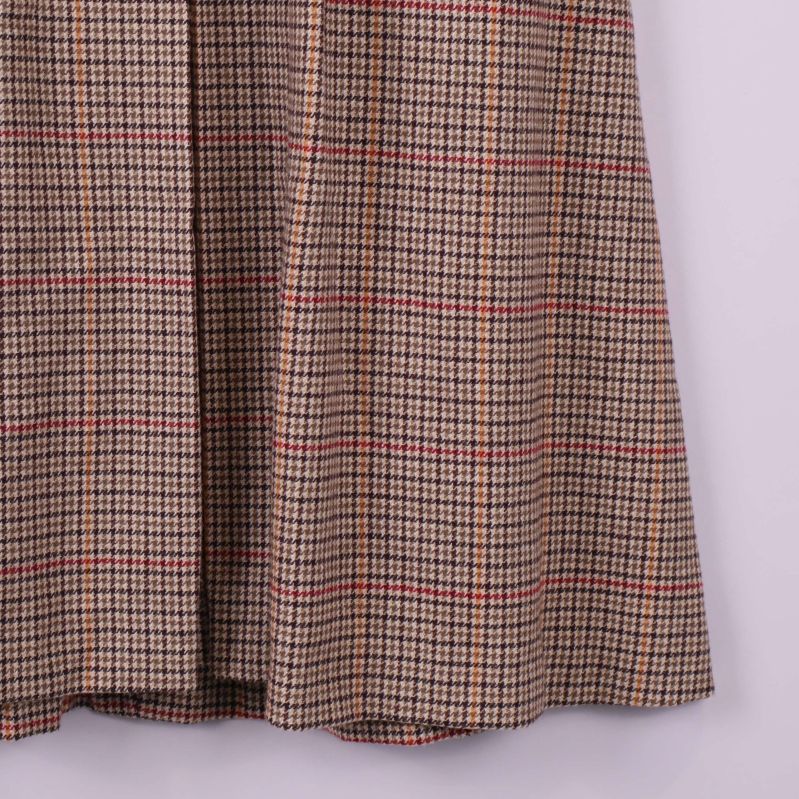 Nedre del av rutmönstrad kjol med brun, röd och senapsgul färg