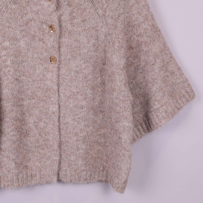 Nedre delen av beige kofta med ribbad kant