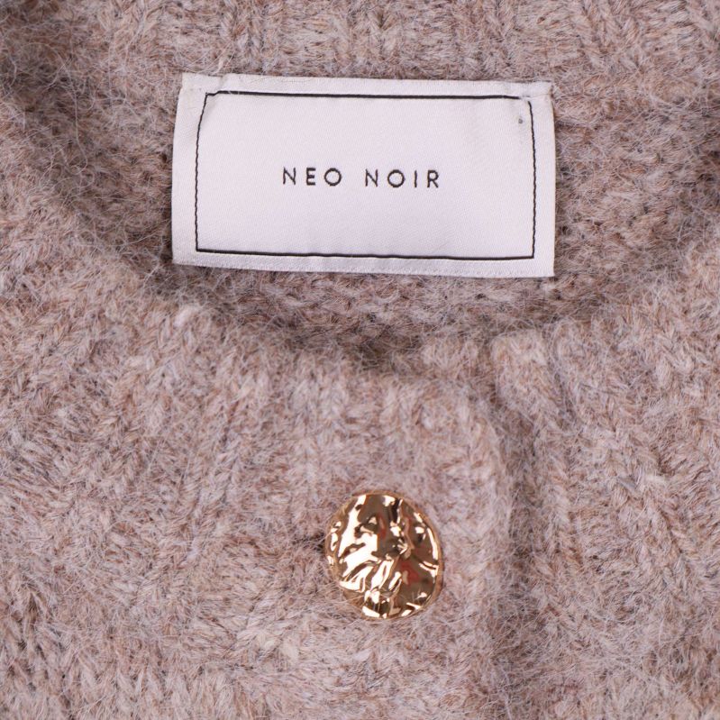 Närbild på Neo Noir-etikett och guldknapp