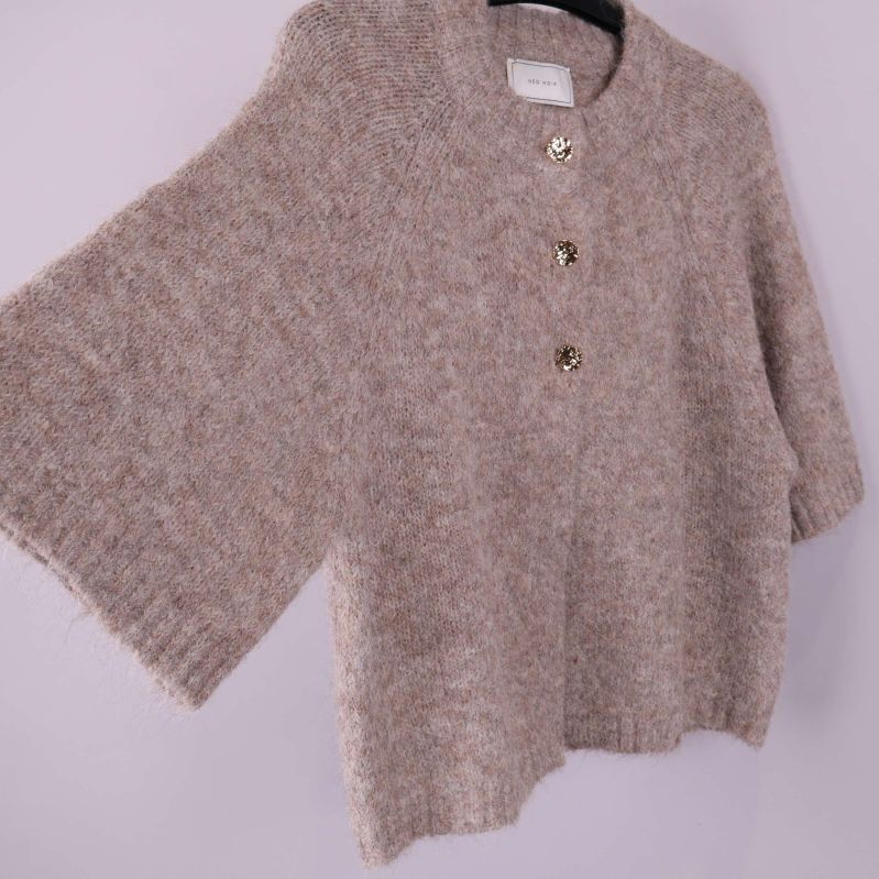 Beige kofta med tre guldknappar i sned vinkel