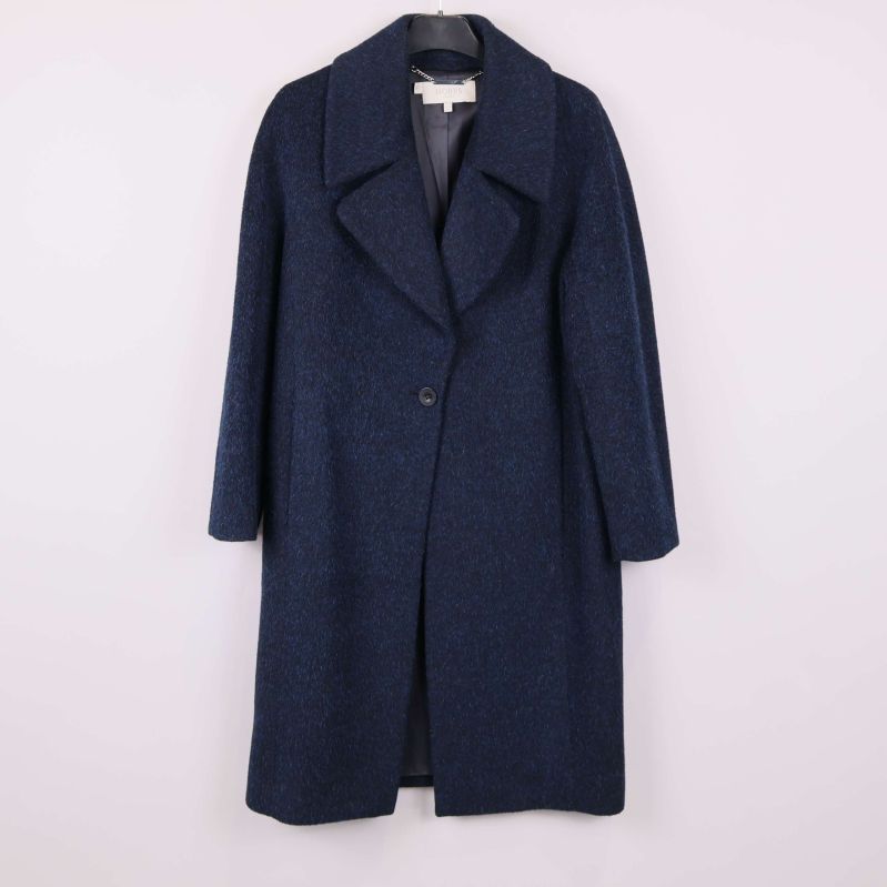 Mörkblå kappa med bred krage upphängd mot ljus bakgrund