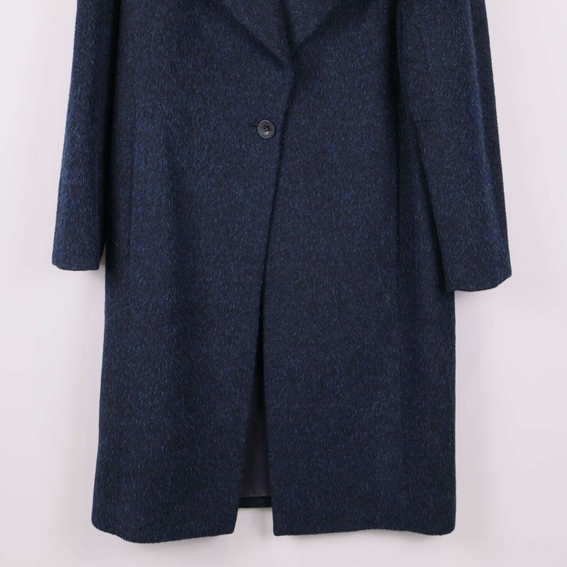 Närbild på knäppning och nedre delen av kappan