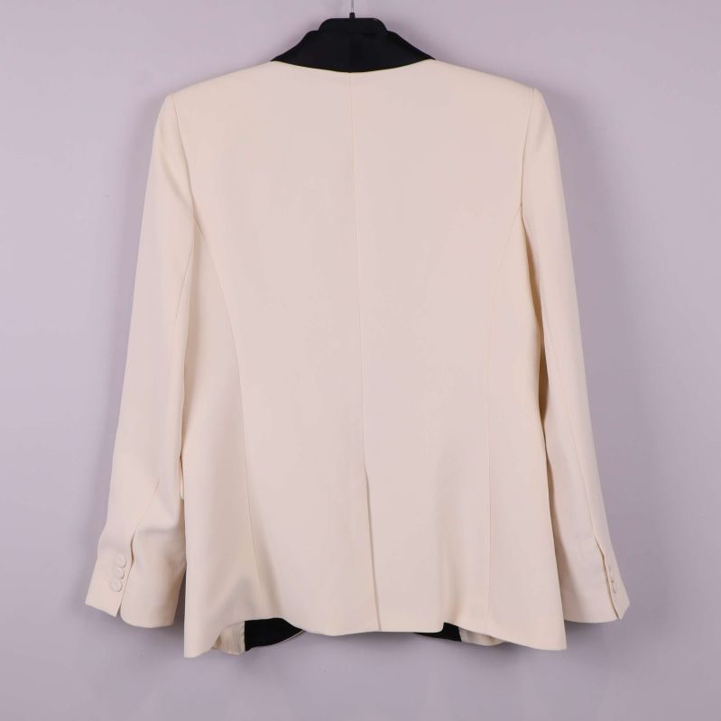 Baksidan av cremevit kavaj med slits