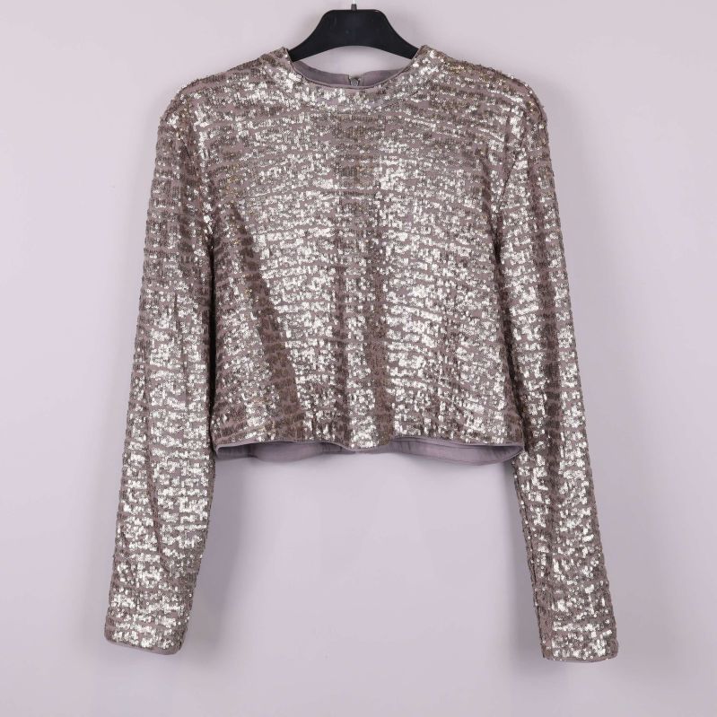 Paljettopp med långa ärmar sedd framifrån på galge