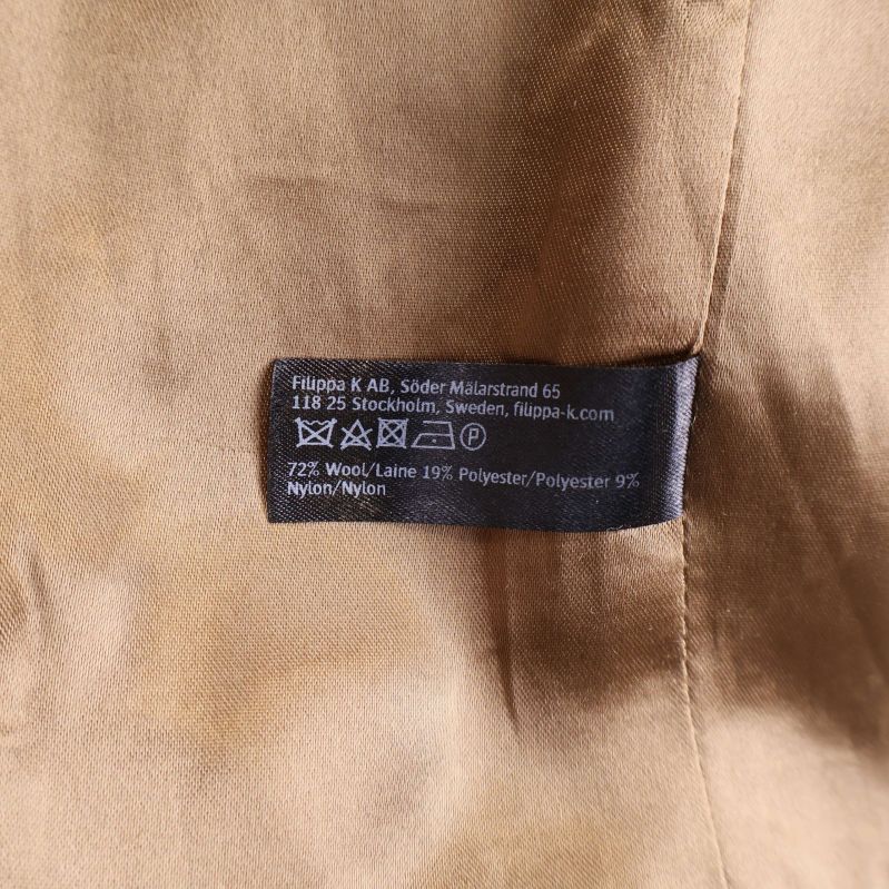 Materialetikett som visar ull, polyester och nylon