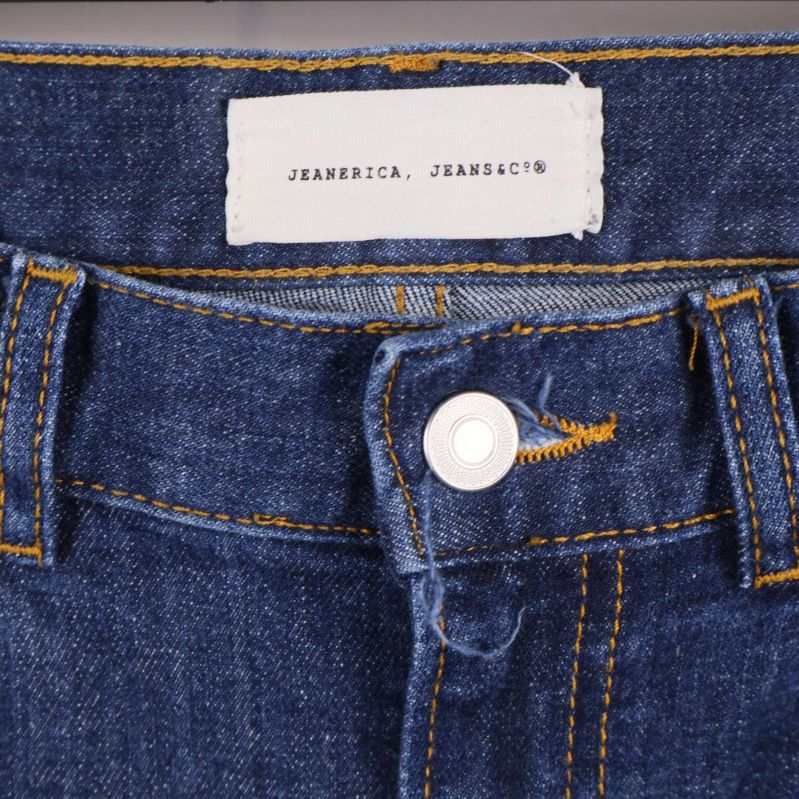 Närbild av midja och knappgylf med etikett Jeanerica