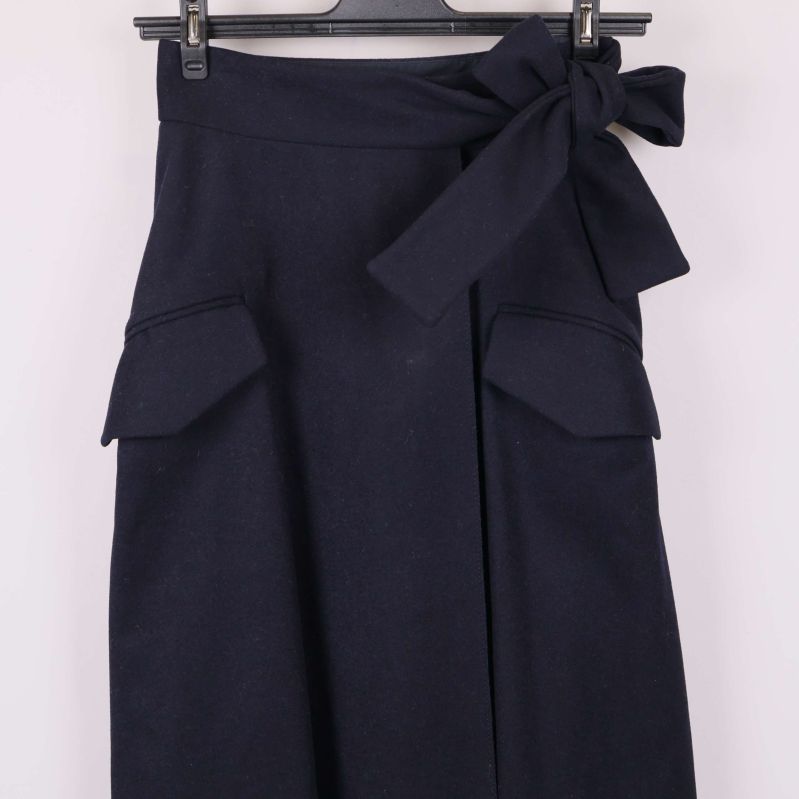 Närbild av fickor och knytdetalj framtill på kjolen