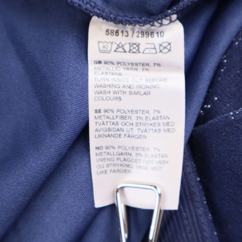 Materiallapp som visar 90% polyester, 7% metall, 3% elastan