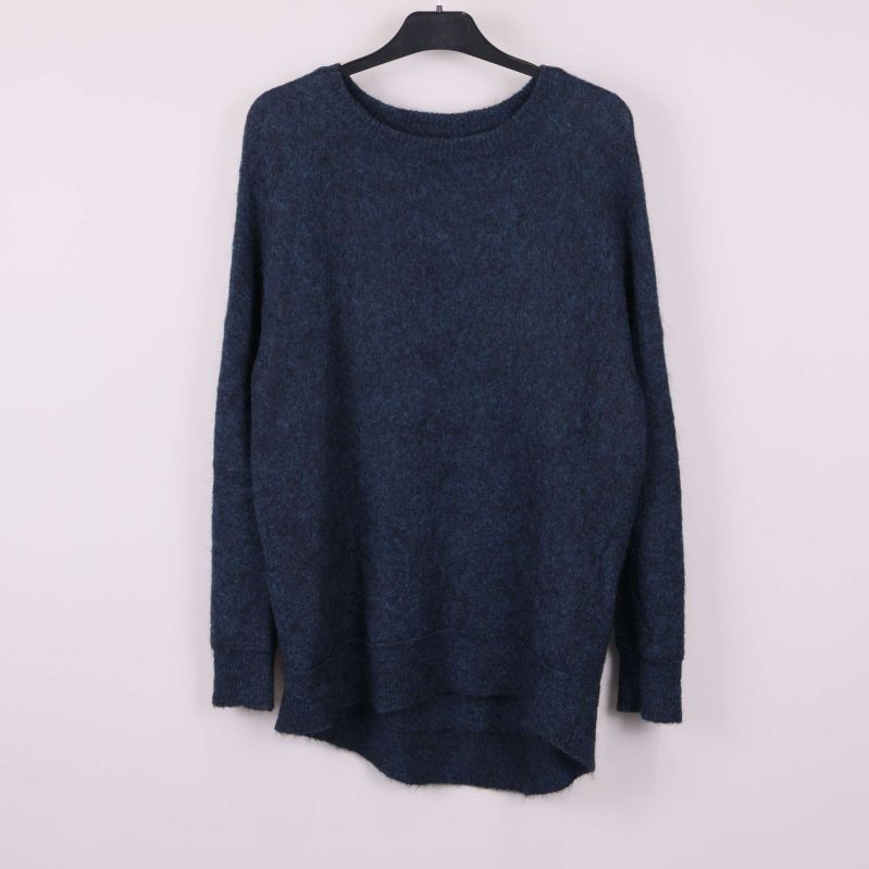 Stickad blå tröja med rund hals hänger på galge