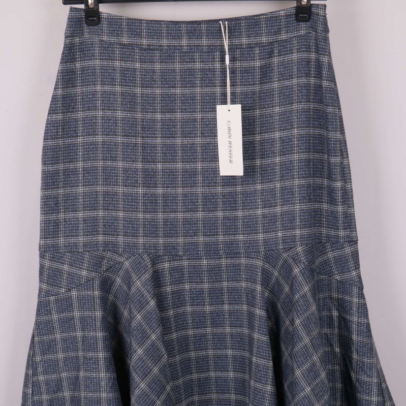 Närbild på rutigt tyg och volangkant längst ner på kjolen