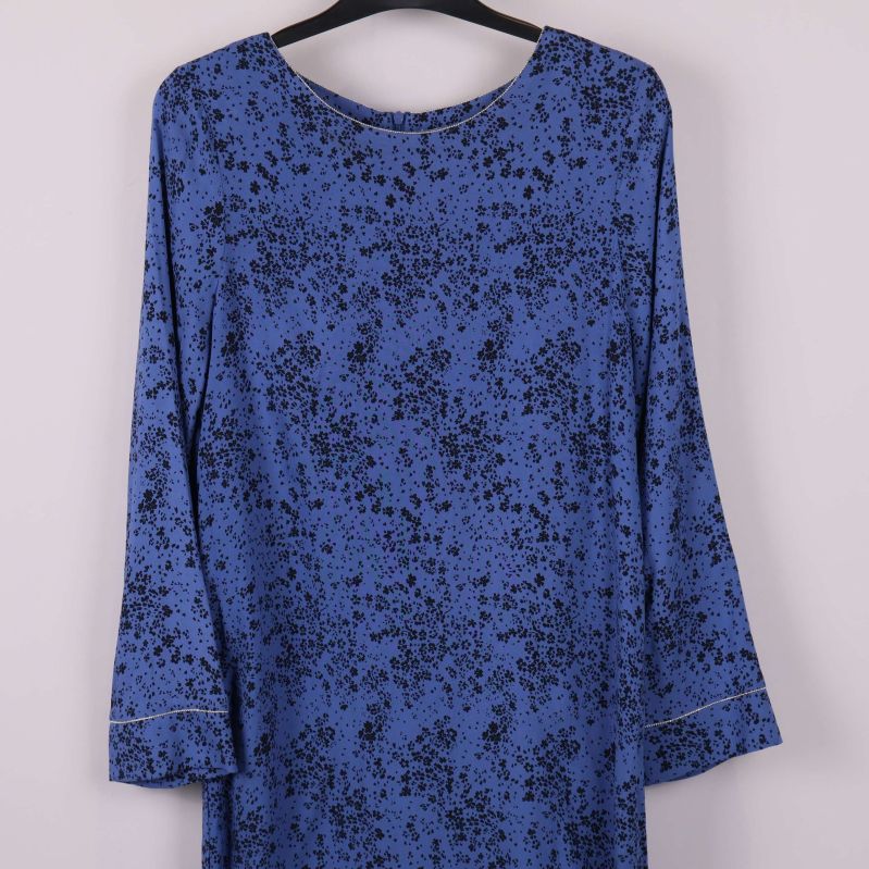 Närbild på övre delen av blå klänning med svart blommönster