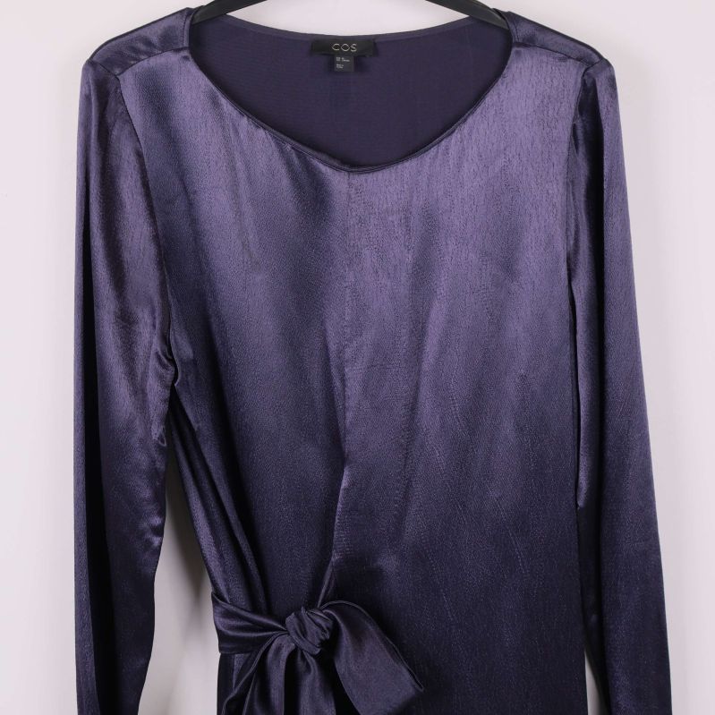 Närbild överdel på lila glansig klänning med lång ärm