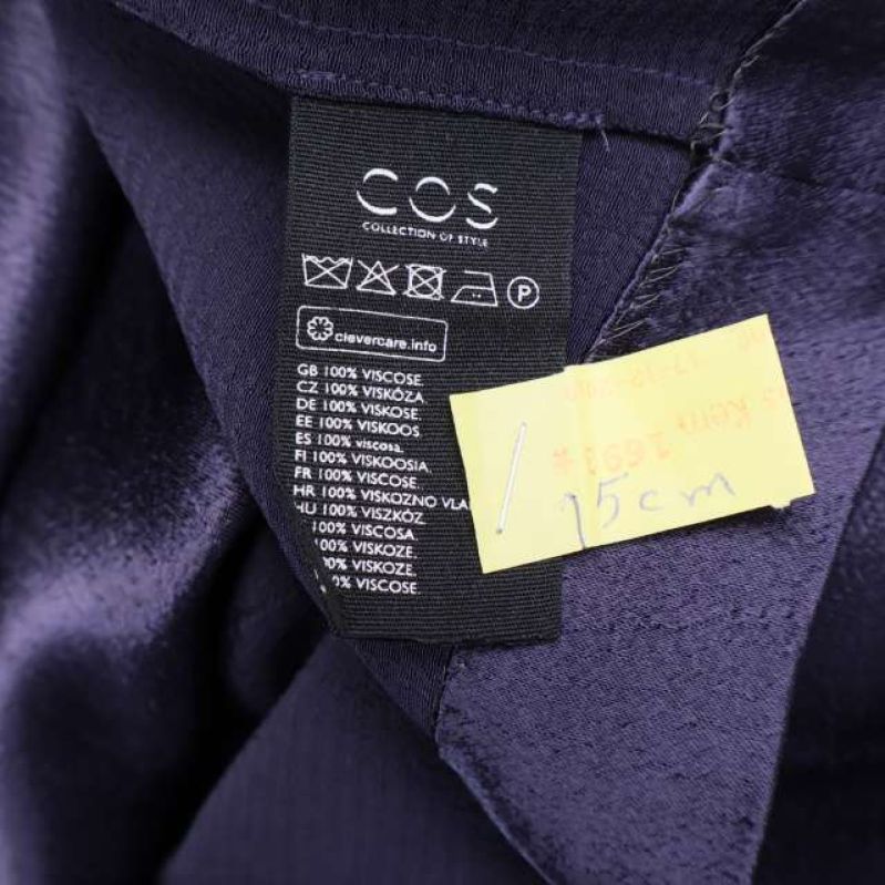 Materiallapp med text 100% viskos i lila klänning