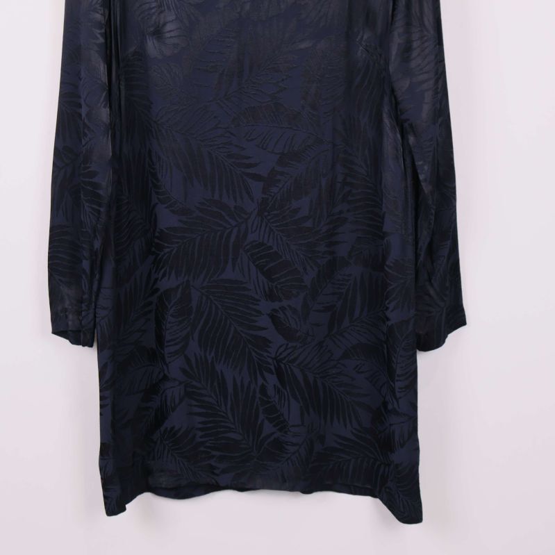 Närbild på nederdelen av mörkblå mönstrad klänning