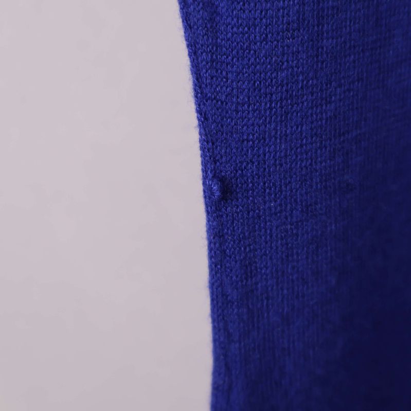 Närbild på liten maska i klänningens tyg