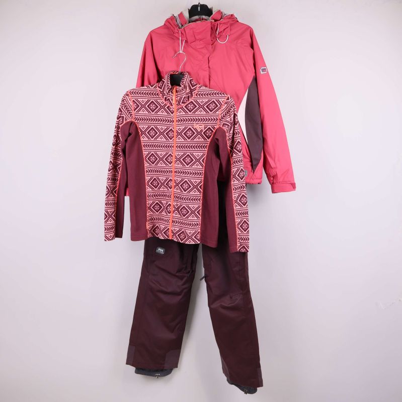 Skidjacka, mönstrad fleece och vinröda byxor upphängda mot vit bakgrund