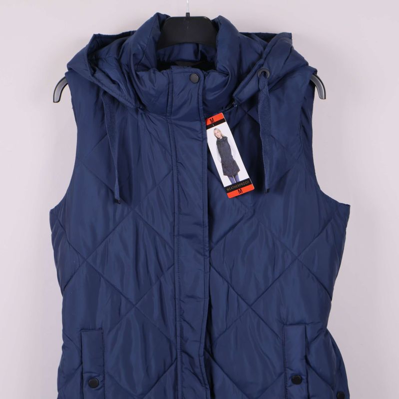 Övre delen av blå quiltad väst med huva och etikett