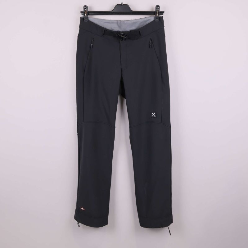 Svarta skidbyxor på galge mot ljus bakgrund framifrån