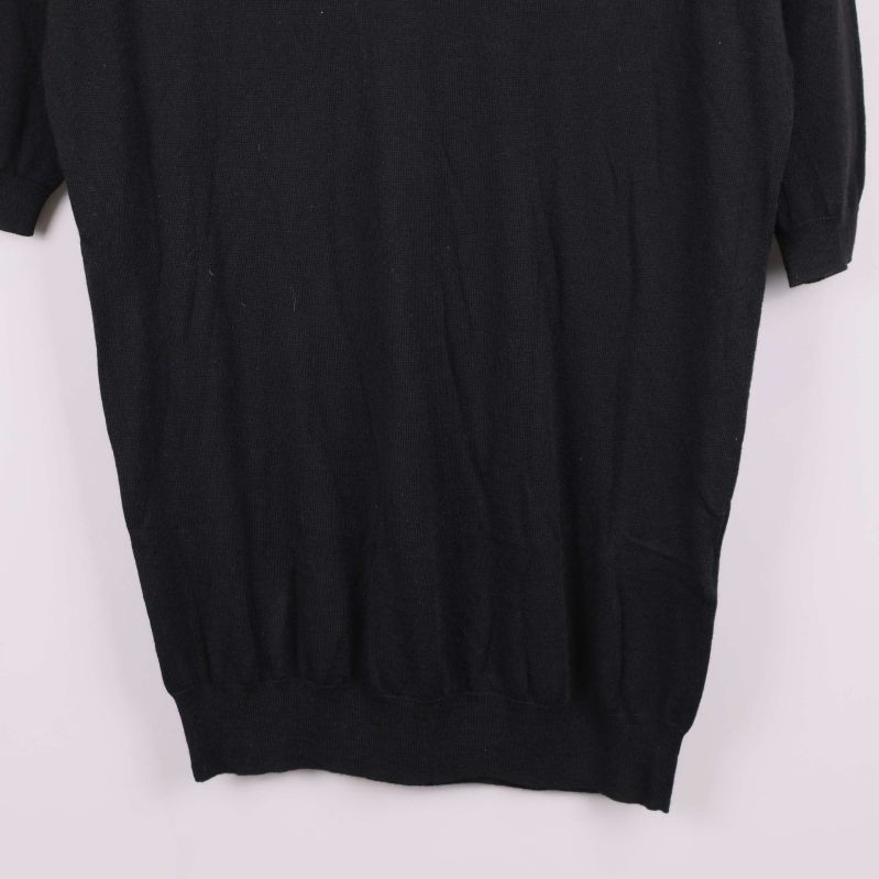 Detalj av nederkanten på svart tröja med resår