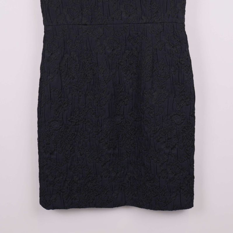 Närbild på kjoldel av klänningen och dess spetsmönster