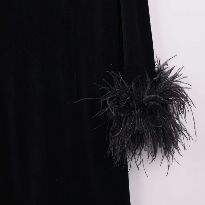 Detaljerad vy av fjädrar på klänningens ärmslut