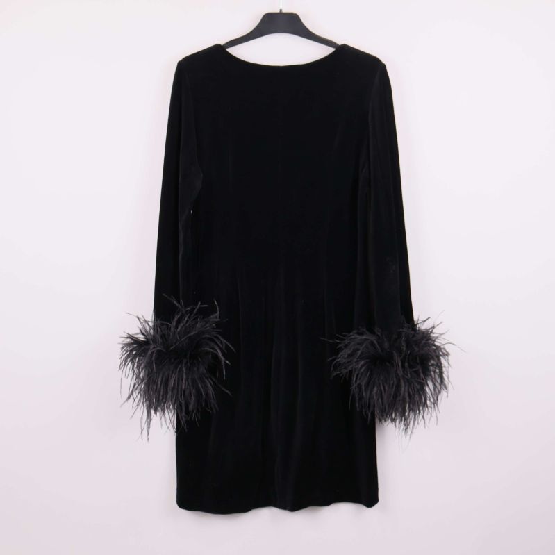 Baksidan av svart klänning med fjädrar på ärmsluten