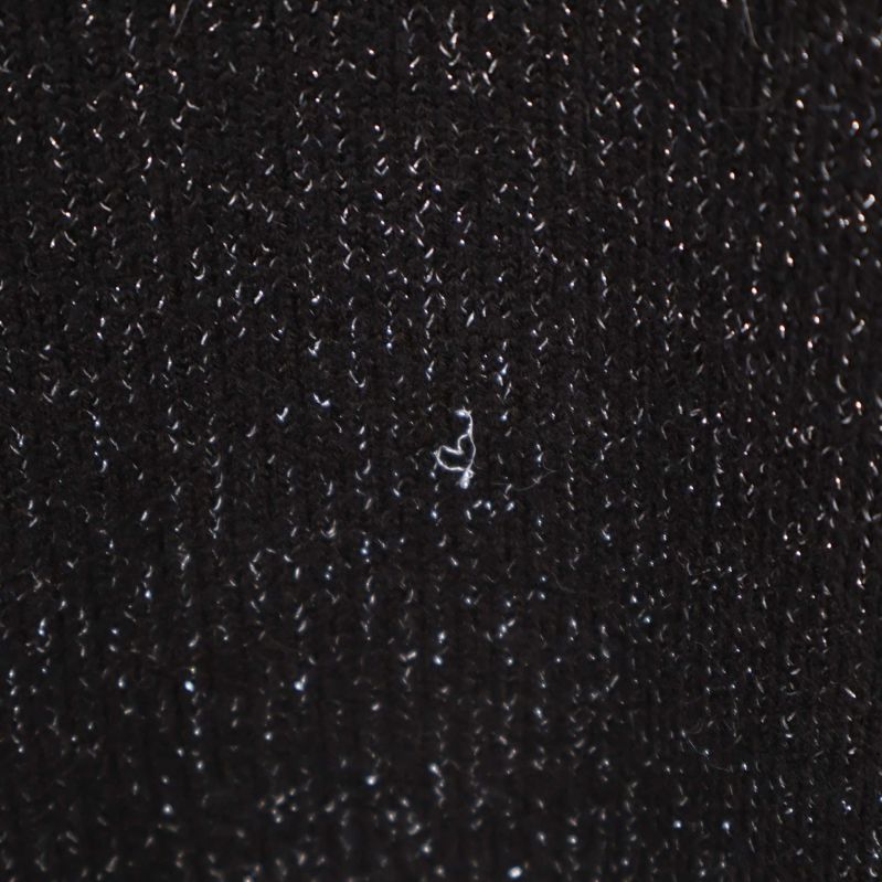 Närbild på mindre defekt i garnet på klänningen