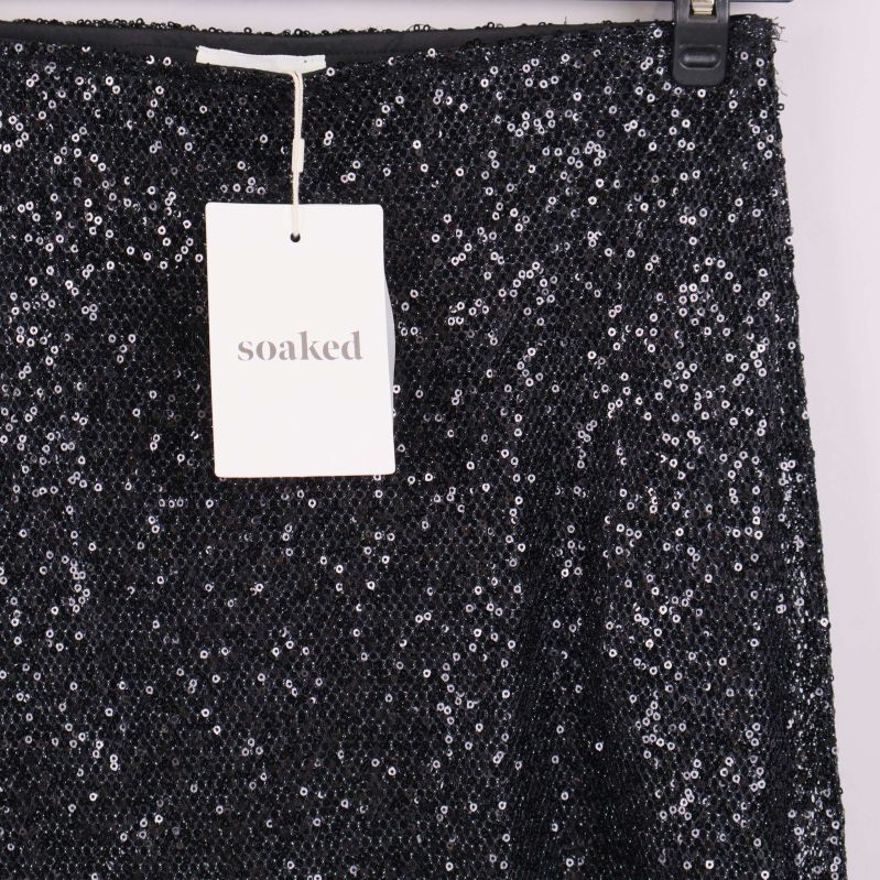 Detaljbild av överdelen på svart paljettkjol med Soaked-tagg