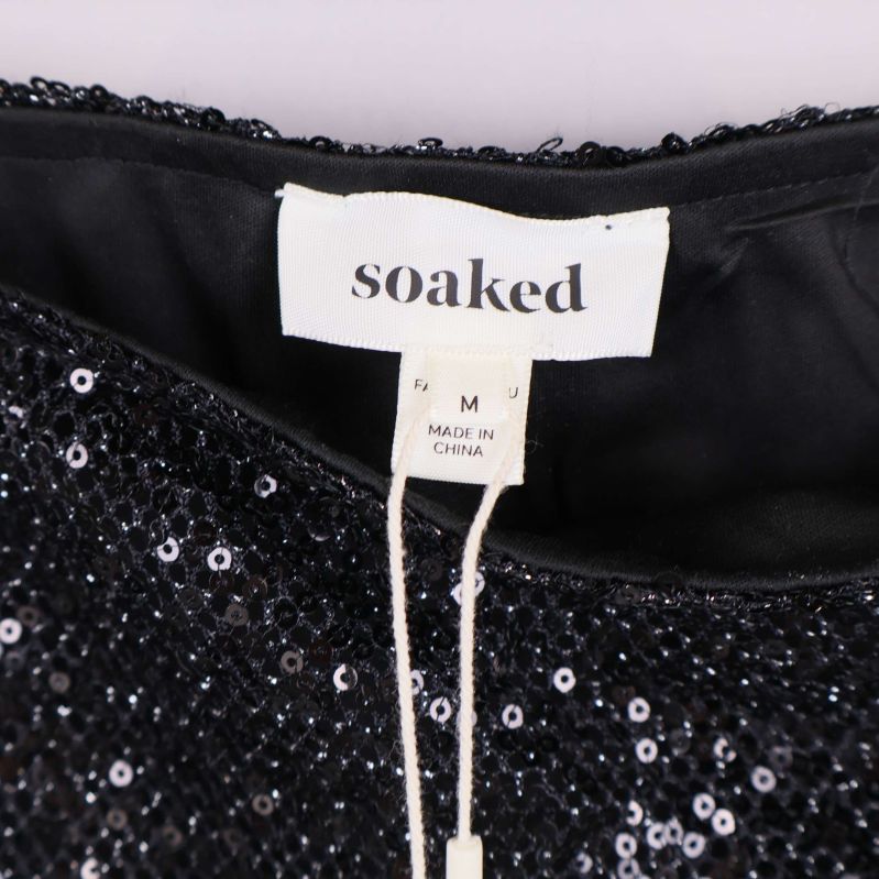 Närbild på Soaked-märkeslapp och storlekslapp i midjan