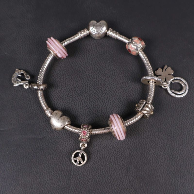Armband sett uppifrån med synliga hjärt- och fredsberlocker