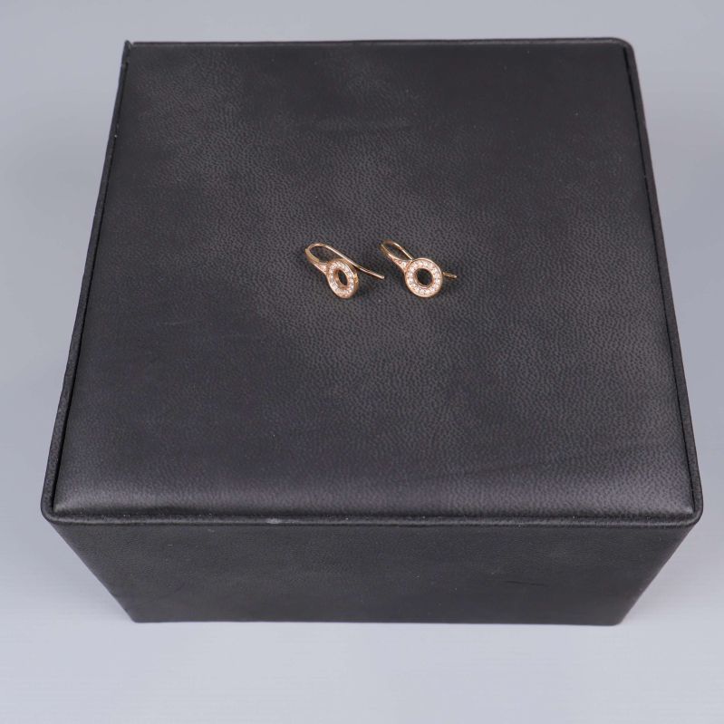 Ett par roséguldsörhängen på svart bakgrund