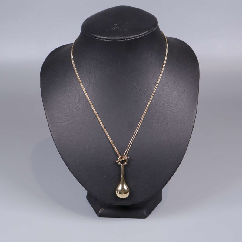 Halsband med droppformat hänge visas på bystställ