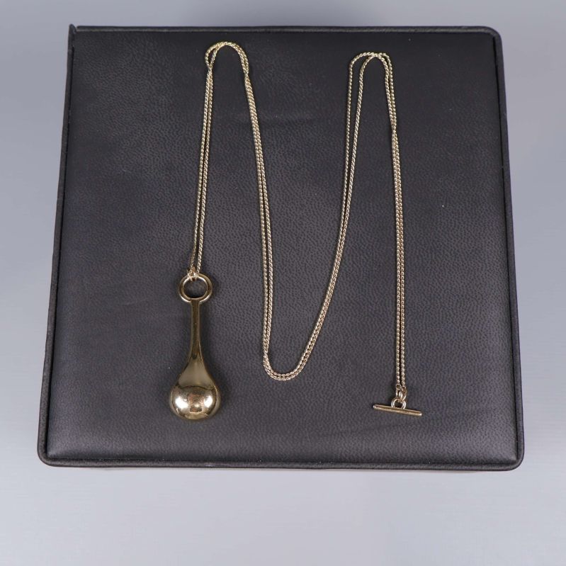 Halsband med kedja och droppformat hänge liggandes platt