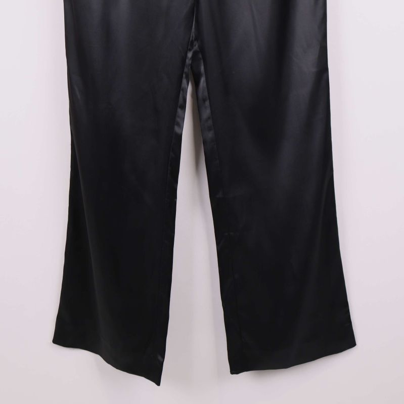 Närbild på benslut av svarta vida byxor