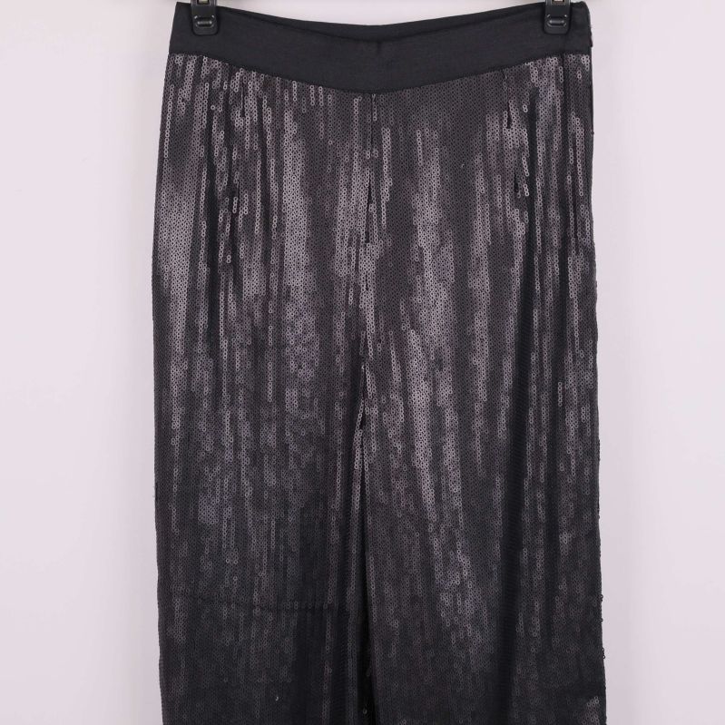 Övre delen av svarta paljettbyxor i fokus