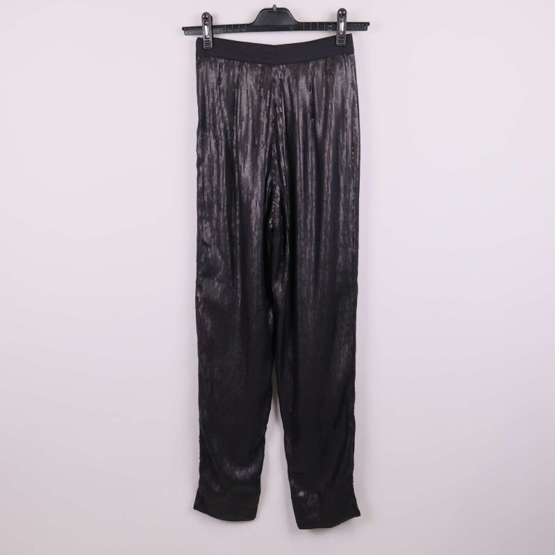 Baksidan av svarta paljettbyxor på galge